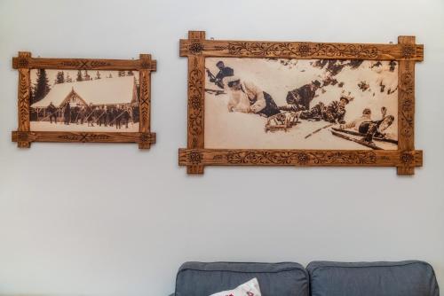 two framed pictures on a wall next to a couch at Wystrugane Apartamenty in Białka Tatrzanska
