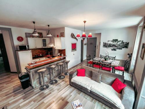 Le Cosy في جوراردُميه: غرفة معيشة مع أريكة ومطبخ مع طاولة