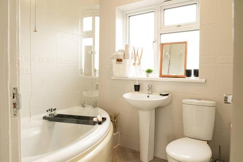 Un baño con bañera, inodoro y lavabo. en 5 Bed House - Free Parking, en Drayton