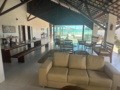 ein Wohnzimmer mit einer Couch sowie Tischen und Stühlen in der Unterkunft Casa beira-mar - Luis Correia in Luis Correia