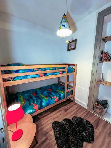 - une chambre avec 2 lits superposés et un tabouret rouge dans l'établissement Le Cosy, à Gérardmer