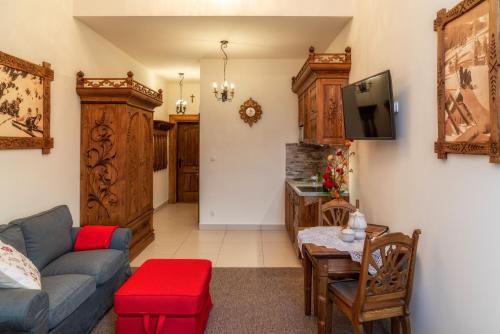 a living room with a couch and a tv at Wystrugane Apartamenty in Białka Tatrzanska
