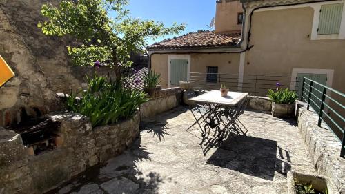 a patio with a table in front of a building at La Mistraline, 2 bedrm 2 bath house in the heart of Provence in Caseneuve