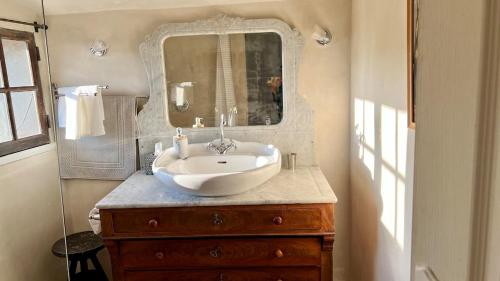 a bathroom with a sink and a mirror on a dresser at La Mistraline, 2 bedrm 2 bath house in the heart of Provence in Caseneuve