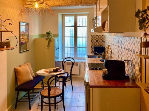 une cuisine avec un comptoir, une table et des chaises dans l'établissement Le Repaire Légendaire, à Carcassonne