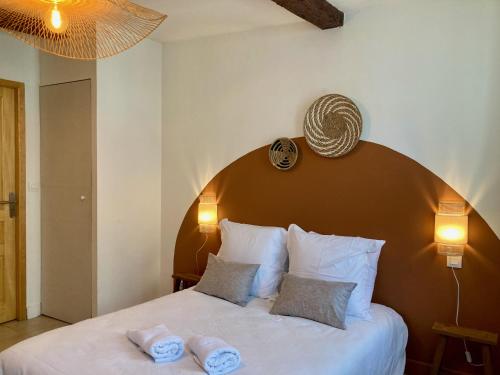une chambre avec un grand lit avec deux serviettes dessus dans l'établissement Le Repaire Légendaire, à Carcassonne