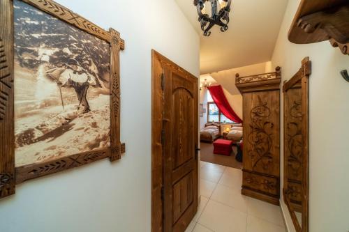 a hallway with a painting on the wall and a door at Wystrugane Apartamenty in Białka Tatrzanska