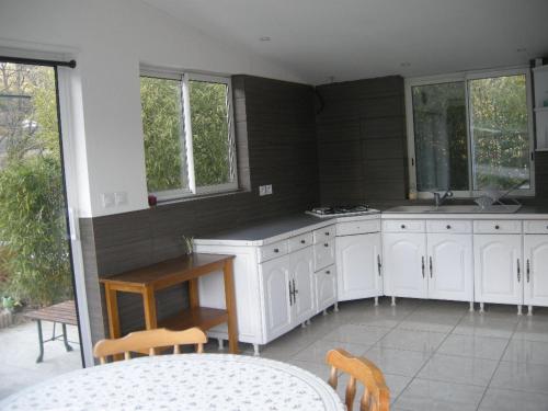 une cuisine avec des armoires blanches et une table et des chaises dans l'établissement holiday home, à Saint-Zacharie