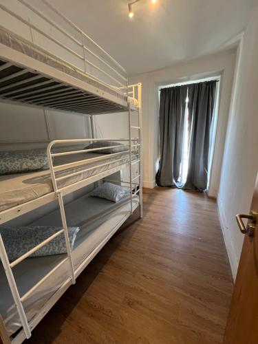 a room with two bunk beds and a wooden floor at Bagetti hostel only for girls in Lisbon