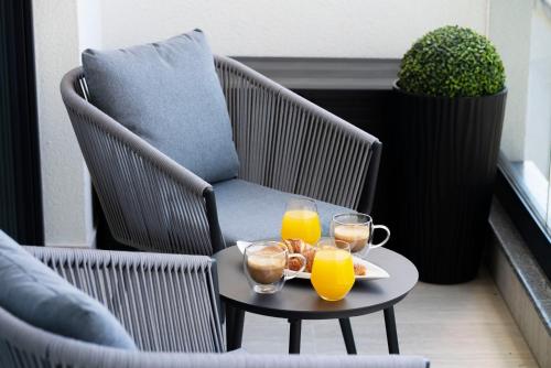 a table with two glasses of orange juice on a balcony at Prestige Apartment Primošten in Primošten