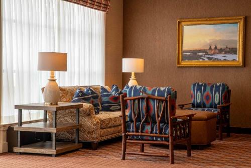 a living room with a couch and chairs in a hotel room at Little America Hotel - Wyoming in Little America