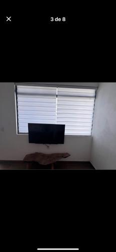 a room with a window with a monitor on a table at Casa orquídea in San Luis de la Paz