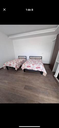 two beds sitting in a room with at Casa orquídea in San Luis de la Paz