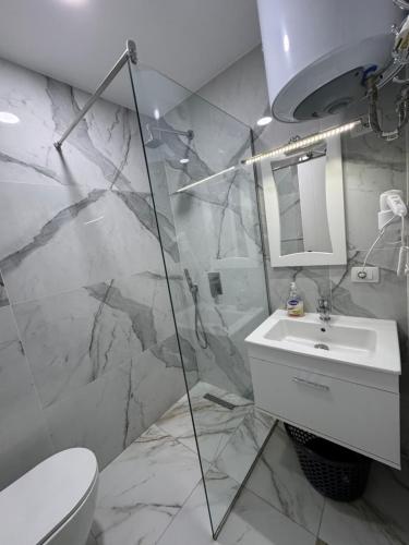 a bathroom with a sink and a toilet and a mirror at Suite Rana Hedhun in Shëngjin