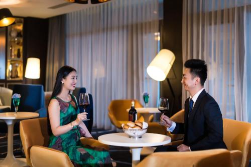 a man and a woman holding glasses of wine at Pullman Nanjing Lukou Airport in Nanjing