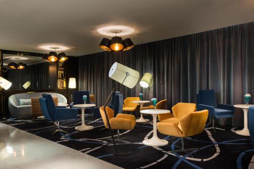 a salon with chairs and tables and a bed at Pullman Nanjing Lukou Airport in Nanjing