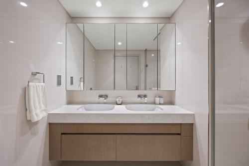 a bathroom with two sinks and a large mirror at YOUR STAY APARTMENTS Luxury Beachfront Living in Dubai