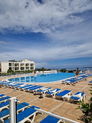 une grande piscine avec des chaises longues et un complexe hôtelier dans l'établissement CANNES VILLA FRANCIA, à Cannes