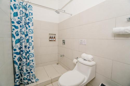 a white bathroom with a toilet and a shower at Ocotal Beach House in Sardinal