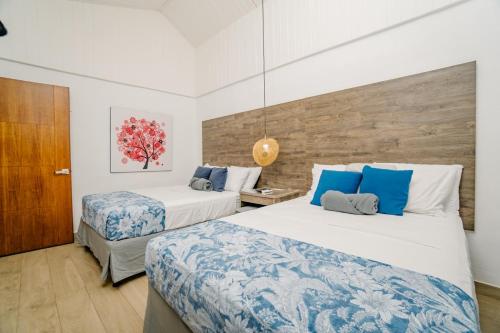 a bedroom with two beds with blue and white sheets at Ocotal Beach House in Sardinal