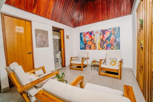 a living room with white furniture and a wooden ceiling at Ocotal Beach House in Sardinal