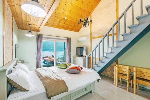 a bedroom with a bed and a staircase at Sinbibada pension in Geoje 