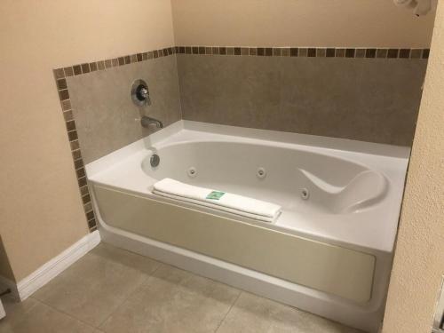 a white bath tub in a bathroom with a tile wall at Universal-Disney Dream 606S - 1 Bedroom in Orlando