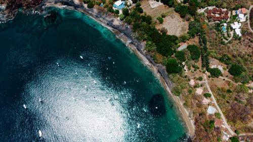 an aerial view of the ocean with houses and trees at Ocotal Beach House in Sardinal