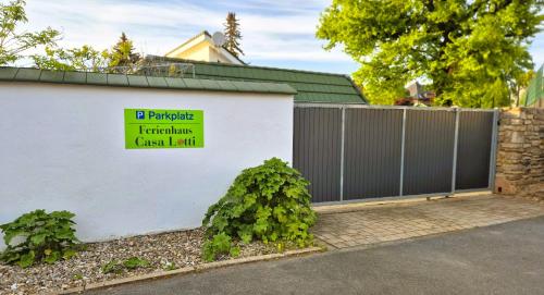 a white building with a gate with a sign on it at Casa Lotti in Sangerhausen