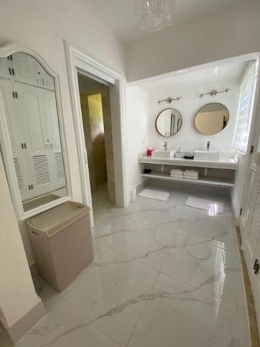 bagno con lavandino, servizi igienici e 2 specchi di Villa Allegria Los Lagos 57 a La Romana