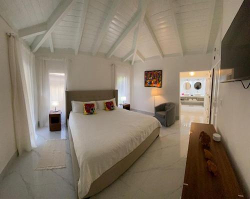 una grande camera da letto bianca con un grande letto di Villa Allegria Los Lagos 57 a La Romana
