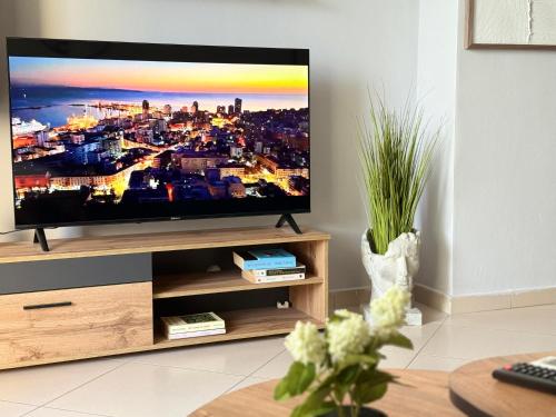 ドゥラスにあるCalea Stays A1のリビングルームの木製の台の上に置かれた薄型テレビ
