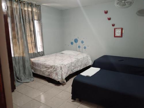 a small bedroom with a bed and a window at Lirio green hostal in Managua