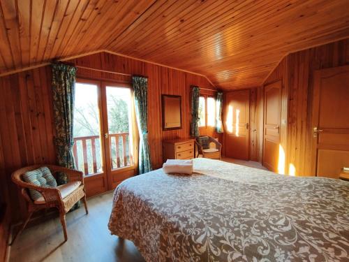 a bedroom with a bed and a wooden ceiling at L'Auzacoise, chalet tout confort pour un séjour inoubliable in Lachapelle-Auzac