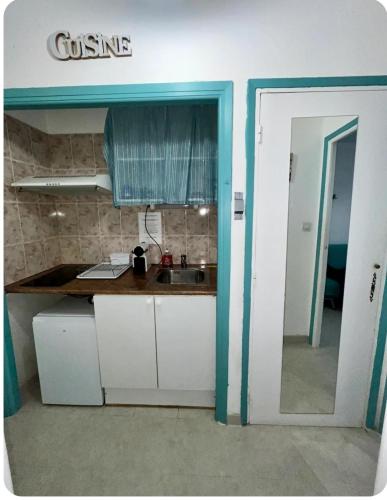 une cuisine avec un comptoir et un évier dans une pièce dans l'établissement Paisible P1 face à la mer a 2 mn de la plage et du Centre Ville, à La Grande Motte