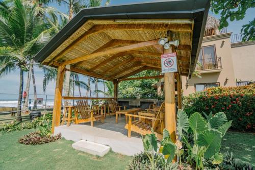 a wooden gazebo with a table and chairs at Casa Lapa Roja in Playa Hermosa