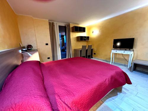 a bedroom with a large bed with a pink blanket at B&B La fontana nelle Langhe in Rodello