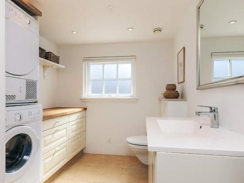 a white bathroom with a sink and a washing machine at Beachfront Beauty in Hasmark - By Traum Ferienwohnungen in Otterup
