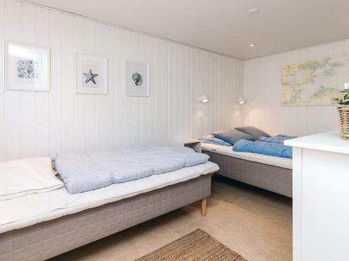 two beds in a room with white walls at Beachfront Beauty in Hasmark - By Traum Ferienwohnungen in Otterup