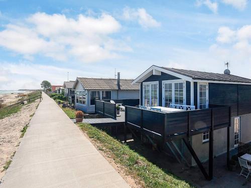 a house on the beach with a sidewalk next to it at Beachfront Beauty in Hasmark - By Traum Ferienwohnungen in Otterup