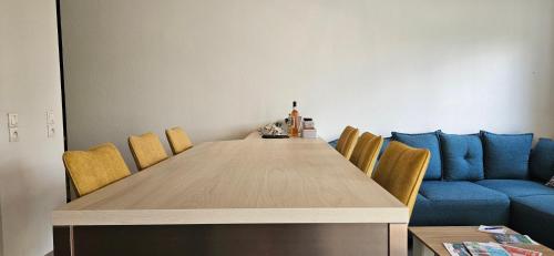 une table à manger avec des chaises et un canapé bleu dans l'établissement Lovely apartment in Annecy, à Annecy