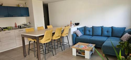un salon avec un canapé bleu et une table dans l'établissement Lovely apartment in Annecy, à Annecy