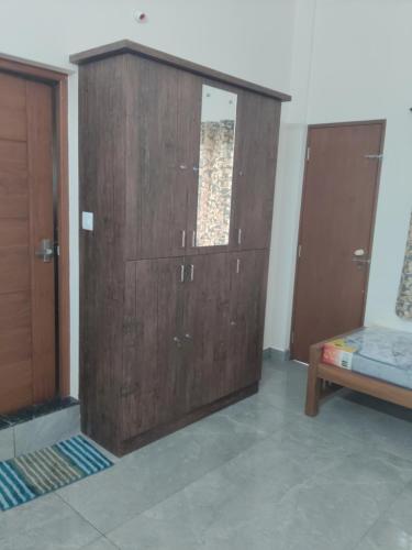Zimmer mit zwei Holztüren und einem Bett in der Unterkunft COCHIN LADIES Hostel in Kochi