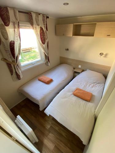 deux lits dans une petite pièce avec une fenêtre dans l'établissement Mobil-home climatisé - Camping Montana 4 étoiles, golfe de Saint-Tropez, à Gassin