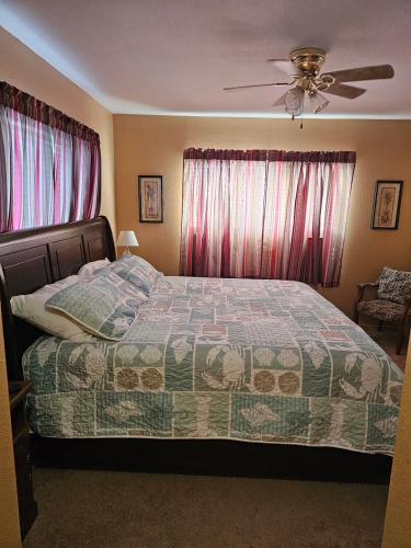 a bedroom with a bed and a ceiling fan at Seashell Memories in Rockport