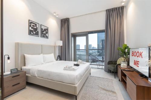 a bedroom with a bed and a tv and a couch at Free housekeeping visits during your stay - StayShort - Awesome Studio at Park View Tower in JVC with Skyline Views in Dubai