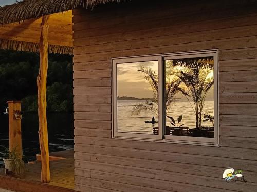 a house with a window with a view of the water at CoralBay Bungalows Solarte in Solarte