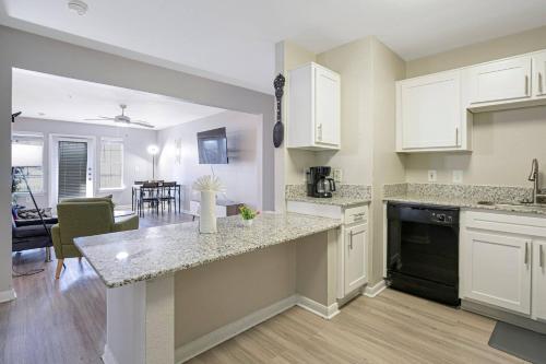 a kitchen with white cabinets and a counter top at Cozy 9-Person Apt w/ WiFi near Downtown Austin in Austin