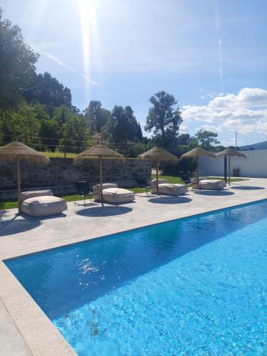 a swimming pool with chairs and umbrellas at Exclusive Pena Rio in Ribeira de Pena