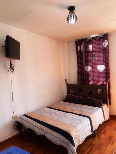 a bedroom with two beds and a tv on the wall at Ugarte Street in Trujillo